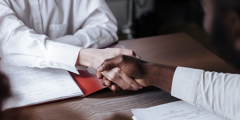 Business handshake over documents representing title deed signing and property contract for Istanbul real estate transaction